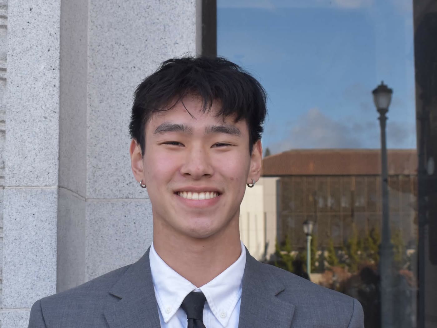 Andy smiling in a suit on the UC Berkeley campus