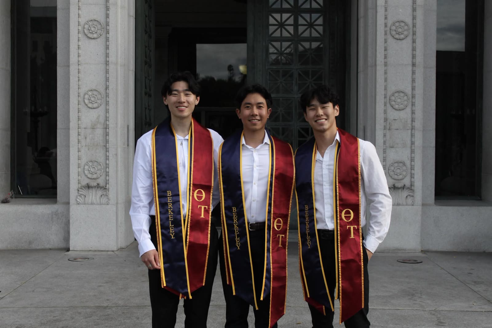 Andy with two friends in graduation stoles at UC Berkeley